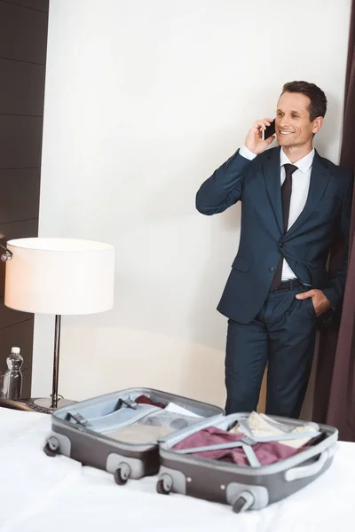 Businessman talking on phone in hotel room — Stock Photo