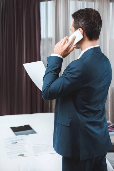 Uomo d'affari in possesso di documenti e parlare al telefono — Foto stock