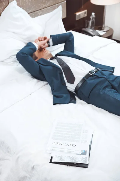 Виснажений бізнесмен лежить на ліжку — стокове фото