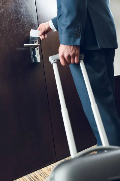 Homme d'affaires avec valise ouvrant la porte — Photo de stock