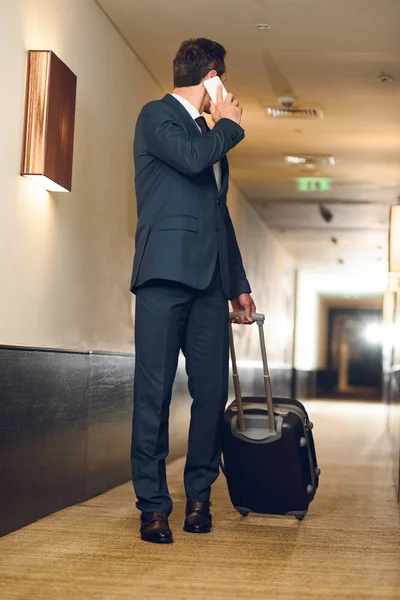 Бізнесмен з валіза розмовляє по телефону — стокове фото