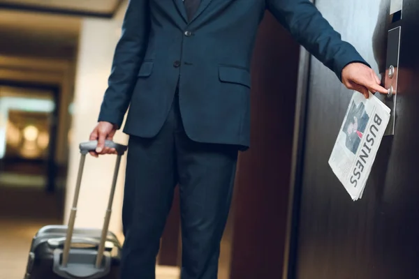 Hombre de negocios con maleta llamando ascensor - foto de stock