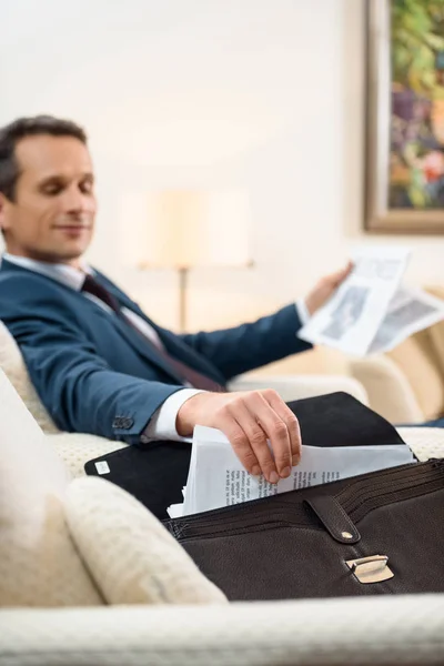 Empresario tomando el papeleo del maletín - foto de stock