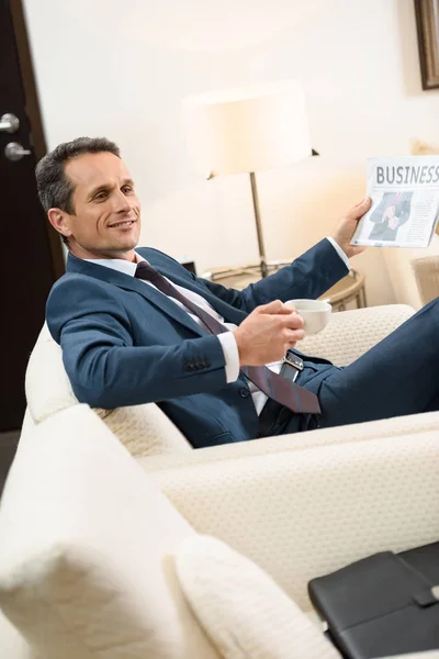 Businessman with newspaper and coffee — Stock Photo