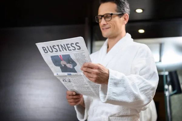 Empresario en albornoz leyendo periódico - foto de stock