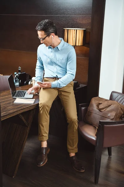 Businessman in headphones using laptop — Stock Photo