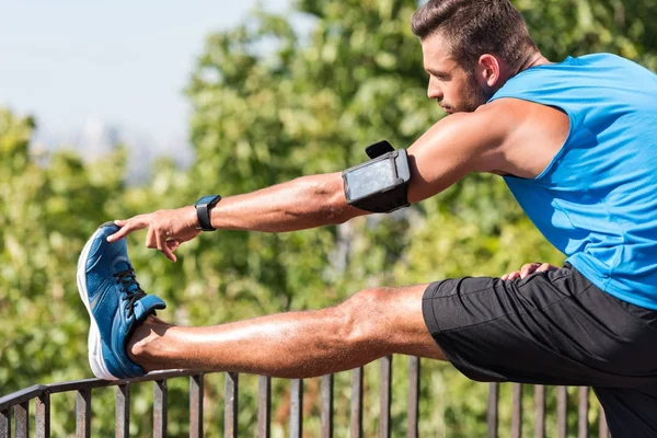 Sportsman stretching in park — Stock Photo