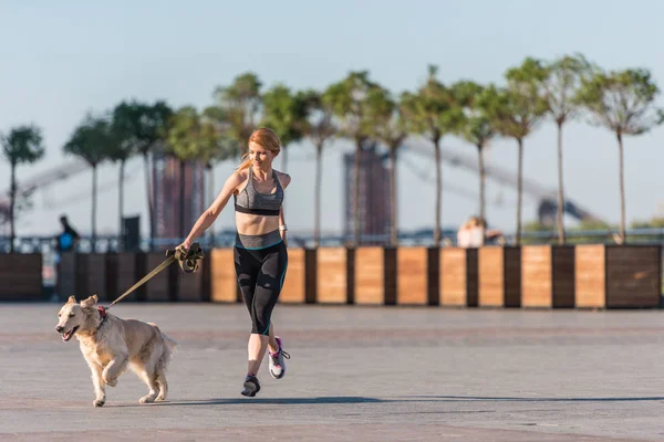 Sportswoman jogging with dog — Stock Photo