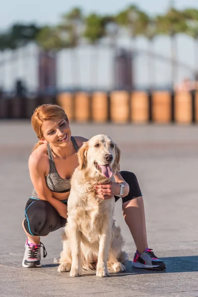 Deportista abrazando perro - foto de stock