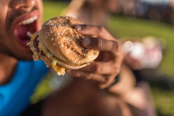 Homem mordendo hambúrguer — Fotografia de Stock