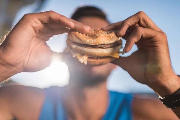 Homme mangeant hamburger — Photo de stock