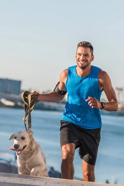 Deportista corriendo con perro - foto de stock