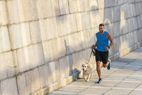 Desportista correndo com cão — Fotografia de Stock
