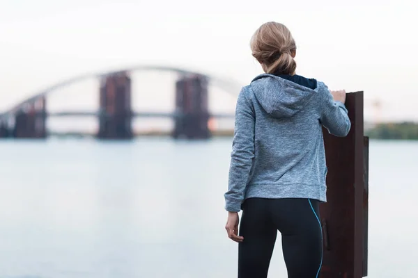 Sportswoman standing on quay — Stock Photo