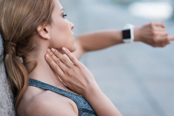 Sportswoman measuring pulse with smartwatches — Stock Photo