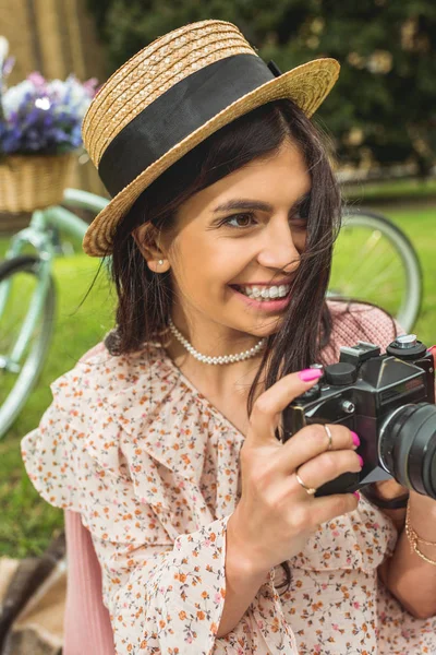 Ragazza alla moda con fotocamera nel parco — Foto stock