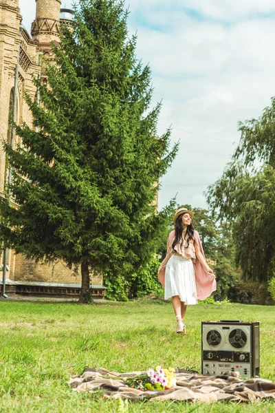 Stylisches Mädchen mit Strohhut im Park — Stockfoto