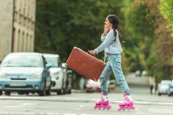 Ragazza in pattini a rotelle con valigia — Foto stock