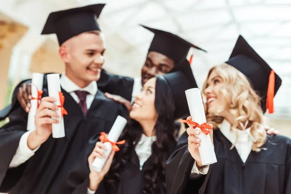 Multiethnic students with diplomas — Stock Photo