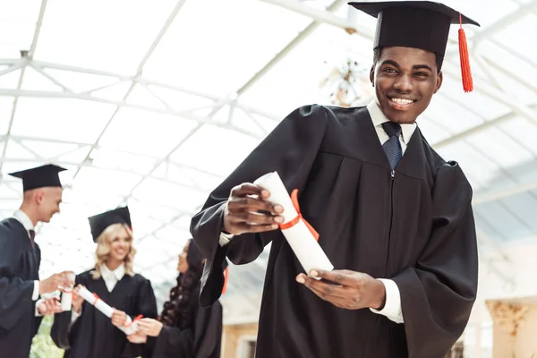 Estudiante graduado mostrando diploma - foto de stock