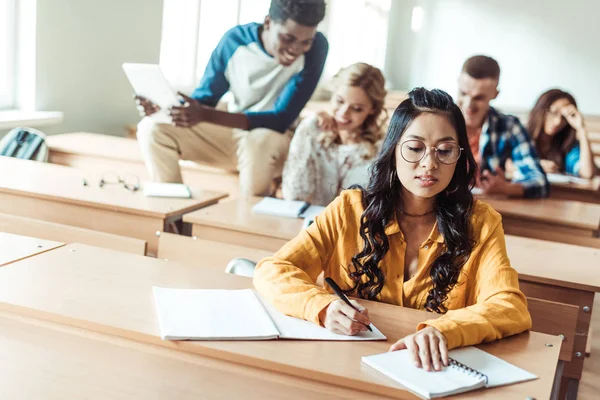 Estudiantes trabajando juntos en el aula - foto de stock