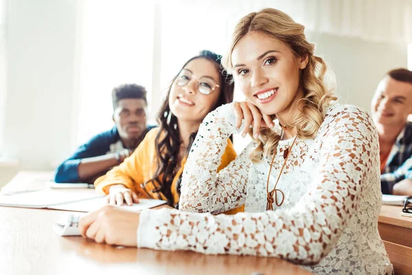 Estudiantes multiétnicos sentados en clase - foto de stock