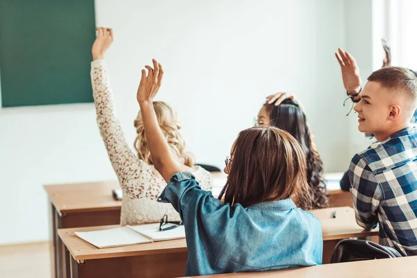 Élèves levant la main en classe — Photo de stock