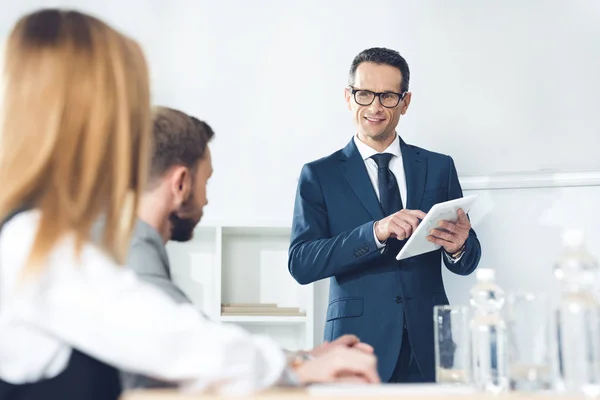 Uomo d'affari con tablet parlare con i partner — Foto stock