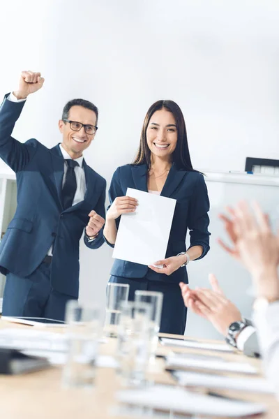 Premiada gerente sosteniendo papel en blanco - foto de stock