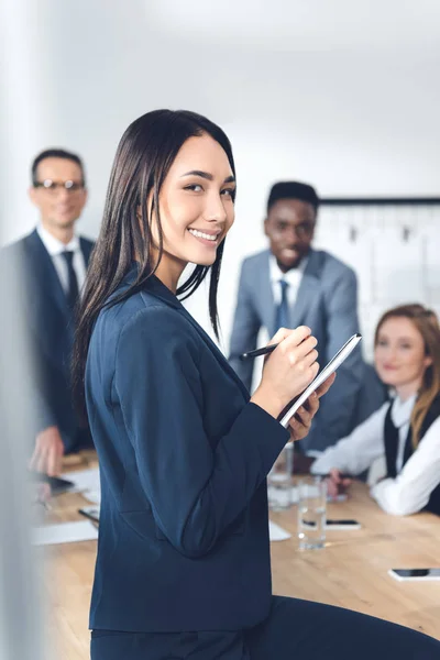 Femme d'affaires écrit dans un cahier — Photo de stock