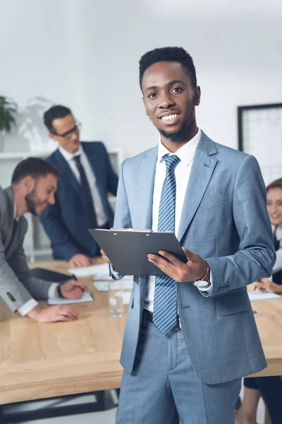 Businessman with clipboard in conference hall — Stock Photo