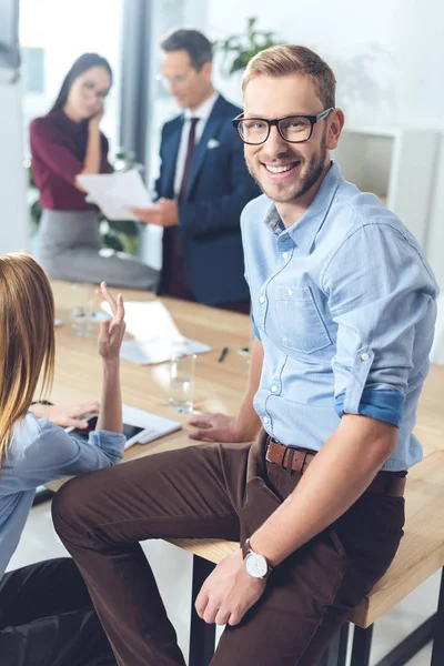 Homme d'affaires assis sur la table — Photo de stock