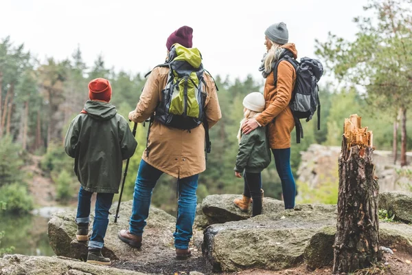 Padres e hijos trekking en el bosque - foto de stock