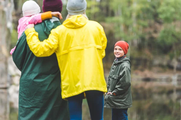 Sourire garçon regardant la famille — Photo de stock