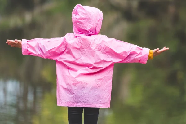 Kid in raincoat with outstretched arms — Stock Photo