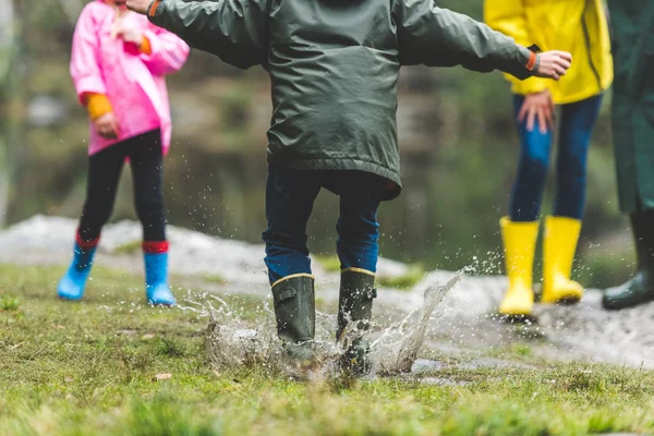 Kind springt in schlammige Pfütze — Stockfoto