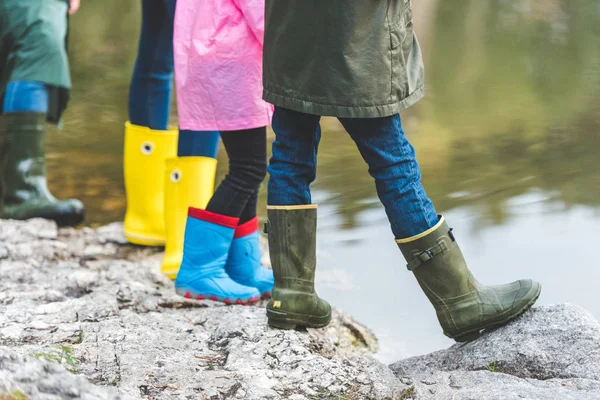 Familie in Gummistiefeln steht auf Felsen — Stockfoto