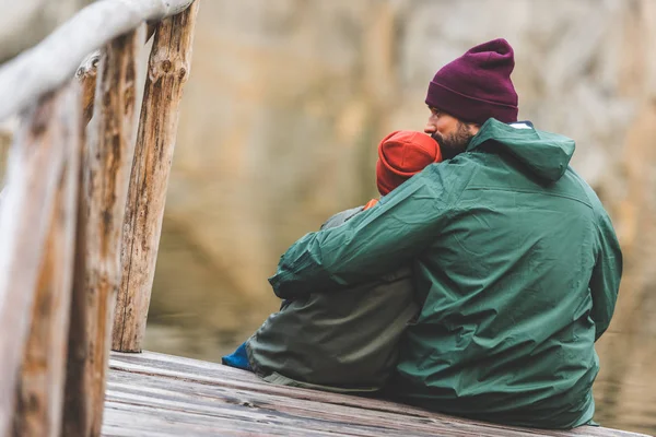 Vater und Sohn sitzen auf Holzbrücke — Stockfoto