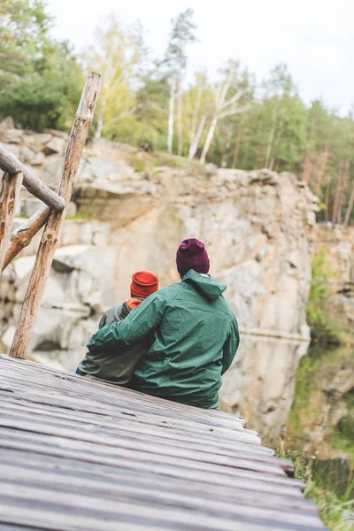 Padre e figlio seduti su un ponte di legno — Foto stock