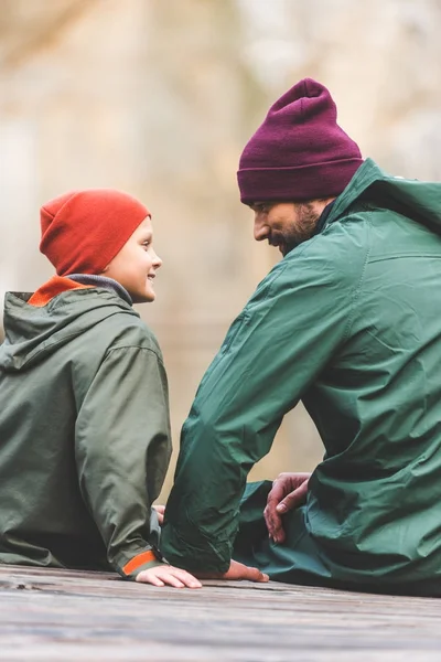 Vater und Sohn sitzen auf Holzbrücke — Stockfoto