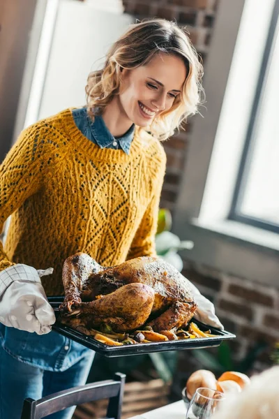 Woman carrying tray with turkey — Stock Photo