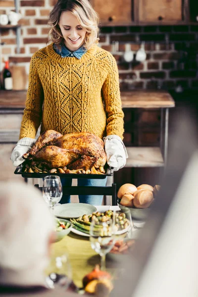 Woman carrying tray with turkey — Stock Photo