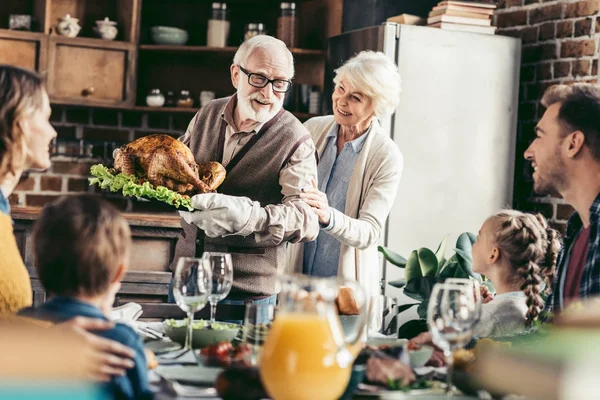 Grandpa with delicious turkey for thanksgiving — Stock Photo