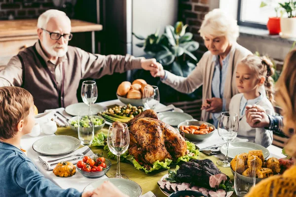Family holding hands and praying on thanksgiving — Stock Photo