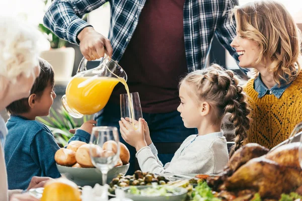 Vater schenkt Tochter Orangensaft ein — Stockfoto