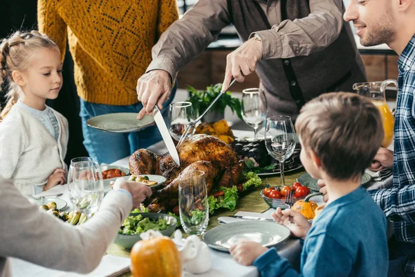 Family cutting thanksgiving turkey — Stock Photo