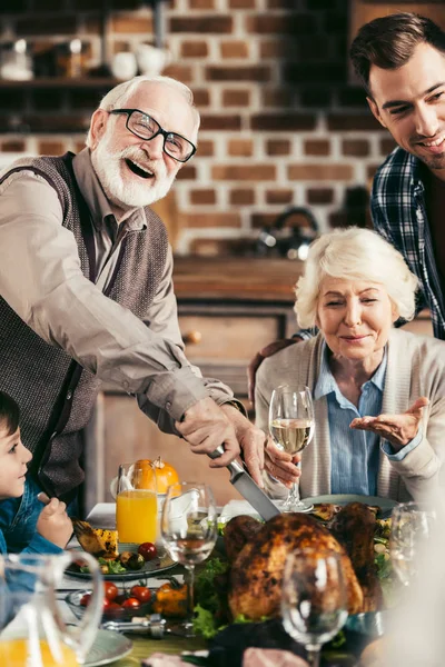 Family cutting thanksgiving turkey — Stock Photo