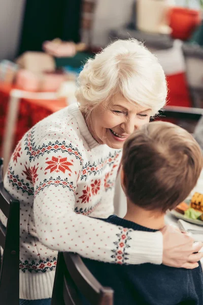 Abuela y nieto hablando en la mesa de Navidad - foto de stock