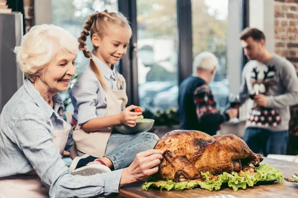 Grandmother and granddaughter with turkey for holiday dinner — Stock Photo