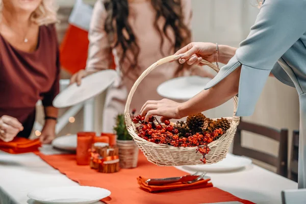 Women decorating christmas table with berries — Stock Photo